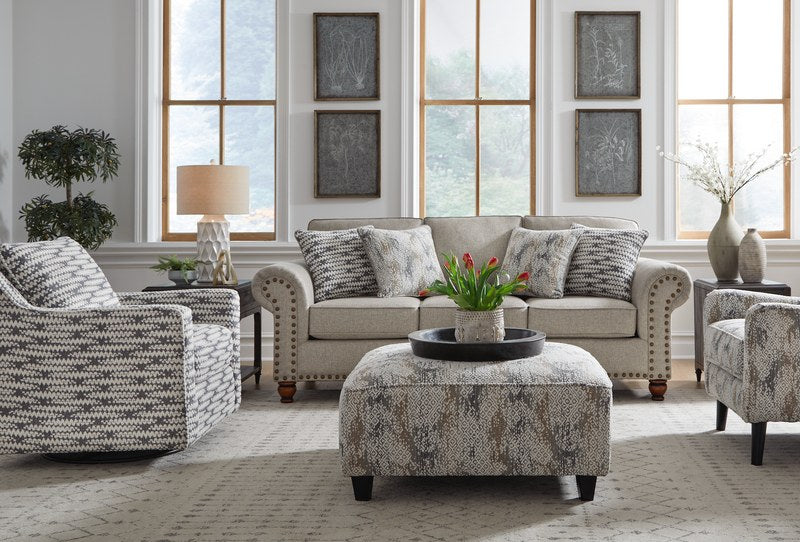 Front-angle lifestyle view of the Fusion PATIGLASS Cocktail Ottoman, positioned as a centerpiece in a modern living room setting.
