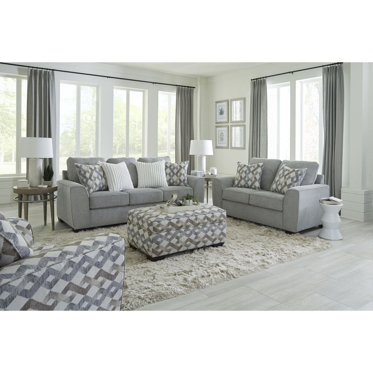 Full front view of the American Furniture Steel Gray sofa, loveseat, and accent chair set, showcasing the product's primary color and modern design in a bright, styled living space.