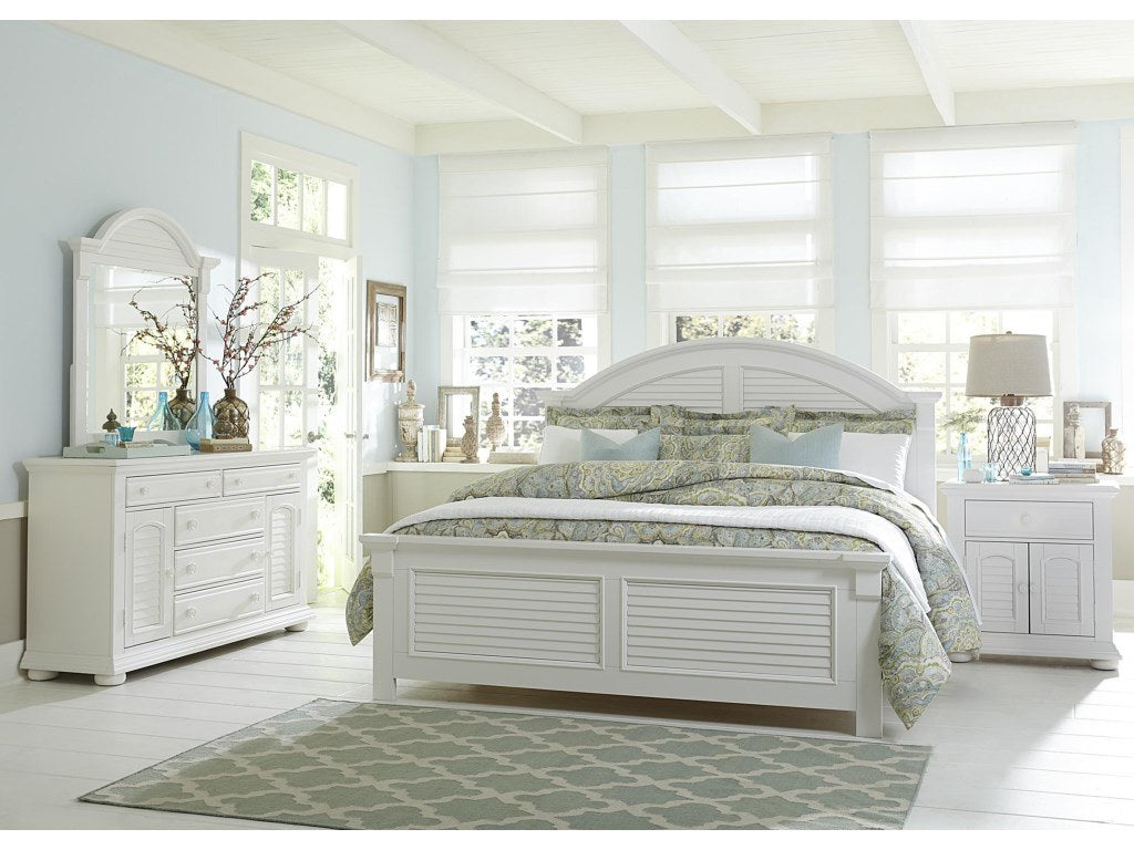 Close-up front view highlighting the full arched mirror, its louvered details, and the top of the dresser it sits upon.