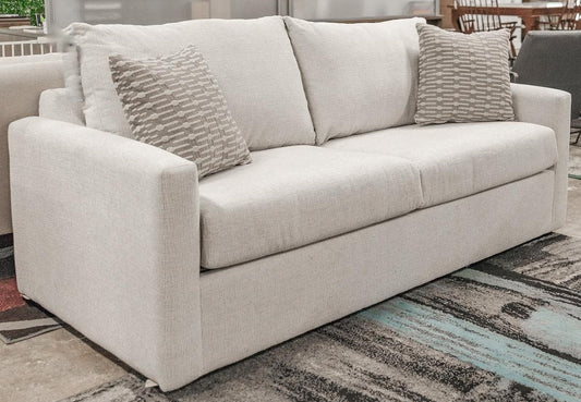 Full front-angle view of the OVER Brax Cera sofa, showcasing its complete design and two accent pillows.